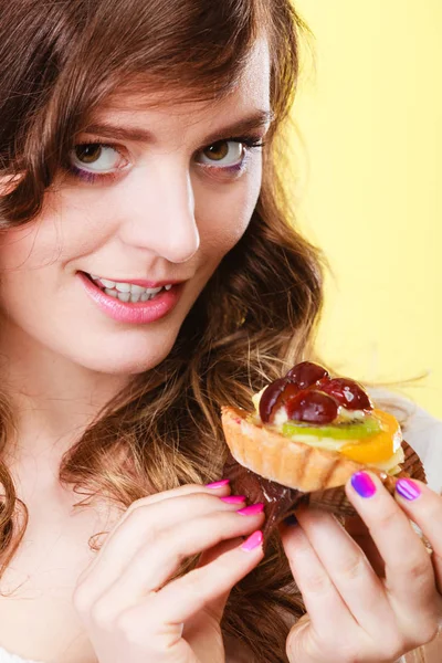 Smiling cute woman holds fruit cake in hand — Stock Photo, Image