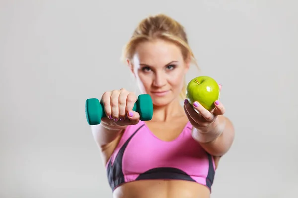 Cuerpo en forma de dieta. Chica sostiene mancuernas y fruta de manzana — Foto de Stock