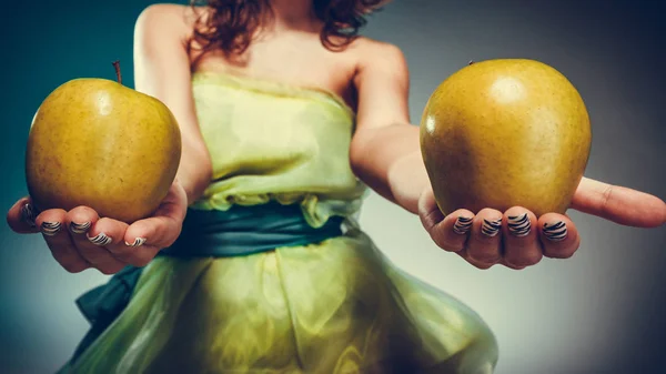 Mulher de vestido segurando maçãs amarelas — Fotografia de Stock