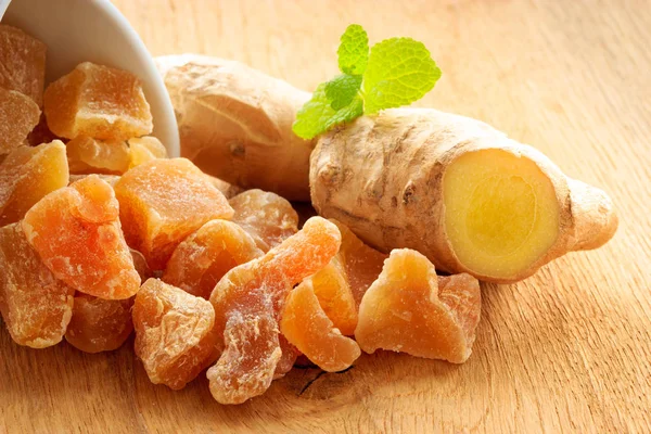 Closeup root and candied ginger on wooden table — Stock Photo, Image