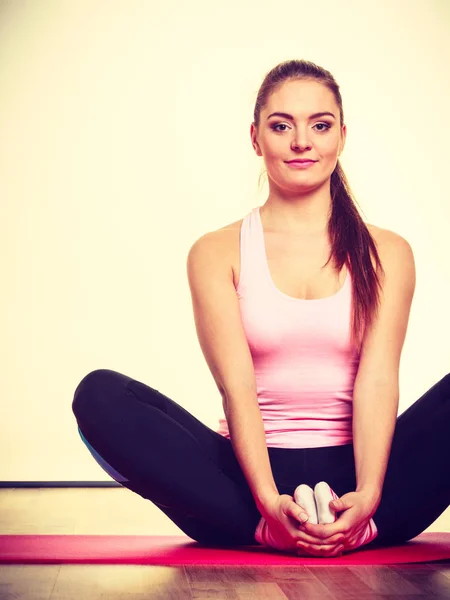 Gymnastic girl sitting on matress. — Stock Photo, Image