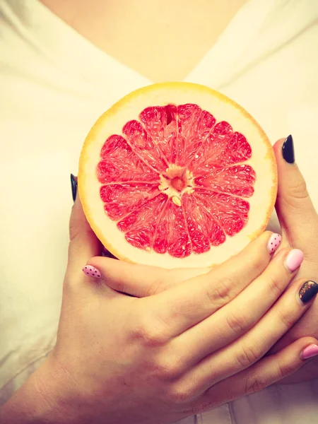 Kvinnan håller hälften av grapefrukt citrus frukt i hand — Stockfoto