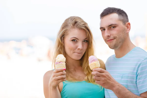 Man and woman eating ice cream on beach — Stock Photo, Image