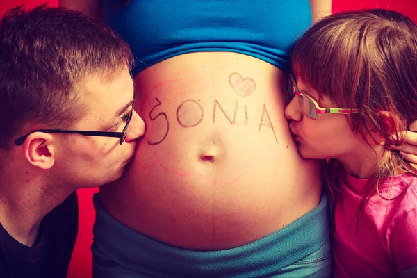 Père et fille embrasser ventre de mère enceinte — Photo