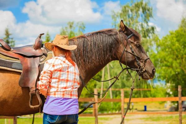 Cowgirl ottenere cavallo pronto per la corsa sulla campagna — Foto Stock