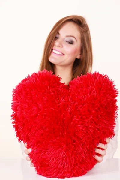 Šťastná žena držící srdce tvarovaný polštář — Stock fotografie