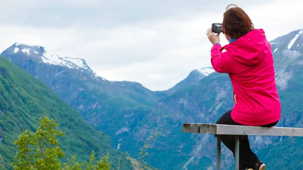 Turista con cámara mirando a la vista panorámica en las montañas Noruega — Foto de Stock
