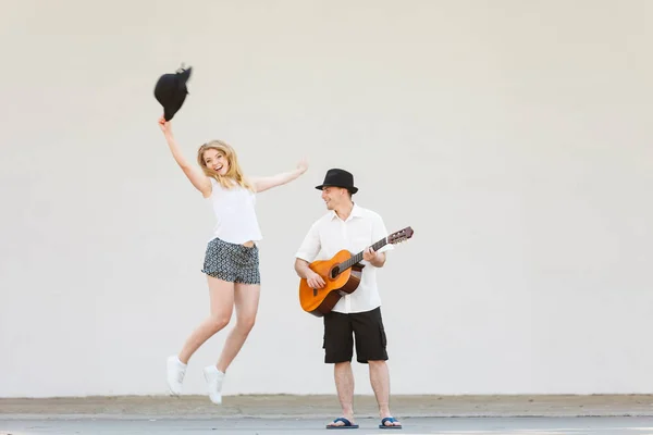 Мужчина играет на гитаре, женщина веселится — стоковое фото