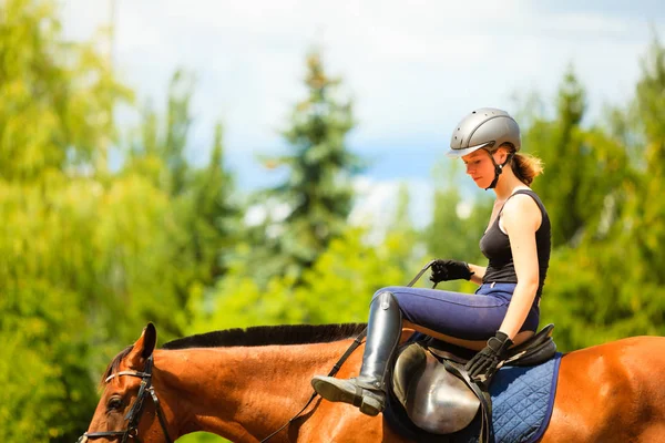 Jockey chica haciendo equitación en campo prado — Foto de Stock