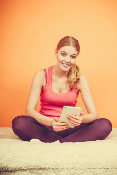 Fitness-Frau Mädchen mit Tablet surft im Internet. — Stockfoto