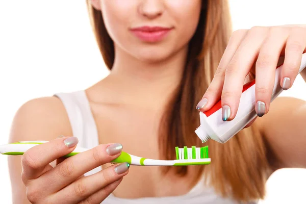 Жінка наносить зубну пасту на зубну щітку — стокове фото