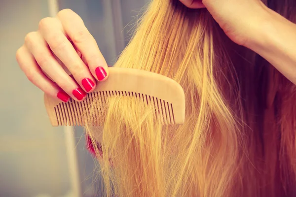 Female hand holding comb closeup — Stock Photo, Image