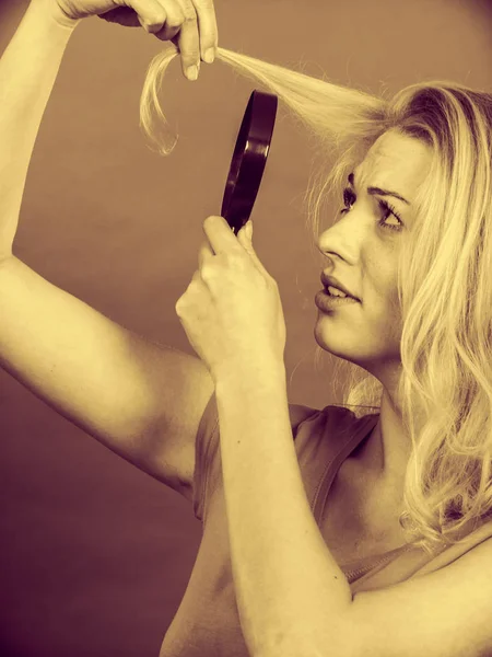 Woman looking at hair through magnifying glass — Stock Photo, Image