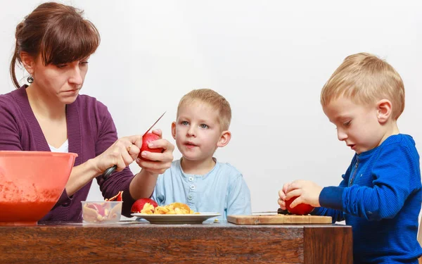 Little boy and mother peeling apples with knife — Stock Photo, Image