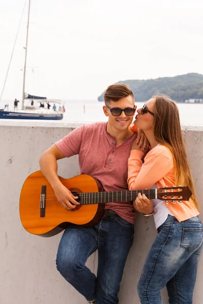 Meisje kussen jonge gitarist. — Stockfoto