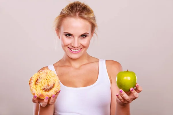 Femme tient gâteau et fruits à la main en choisissant — Photo