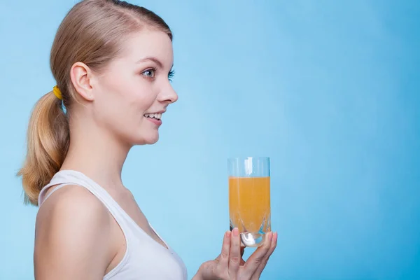 Kobieta trzyma szklankę napoju o smaku pomarańczowym — Zdjęcie stockowe
