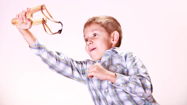 Jonge jongen gebruik sling shot schieten Mandarijn. — Stockfoto