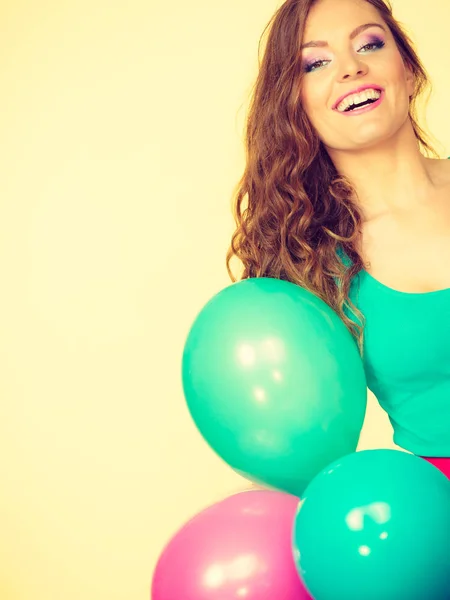 Žena drží spoustu barevných balónků — Stock fotografie