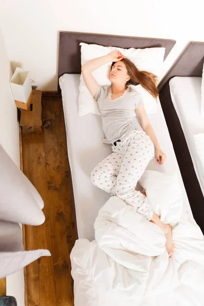 Mujer somnolienta durmiendo en la cama . — Foto de Stock