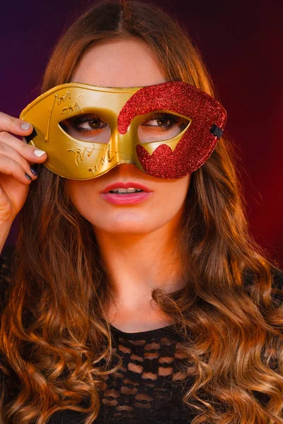 Cara de mujer de primer plano con carnaval máscara roja dorada en la oscuridad —  Fotos de Stock