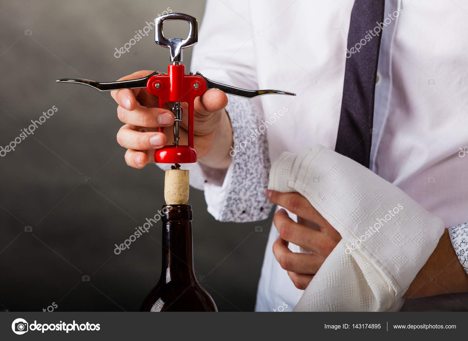 Waiter opens wine bottle. Stock Photo by ©Voyagerix 143174895