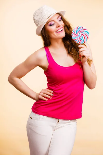 Mujer sostiene colorido caramelo piruleta en la mano — Foto de Stock