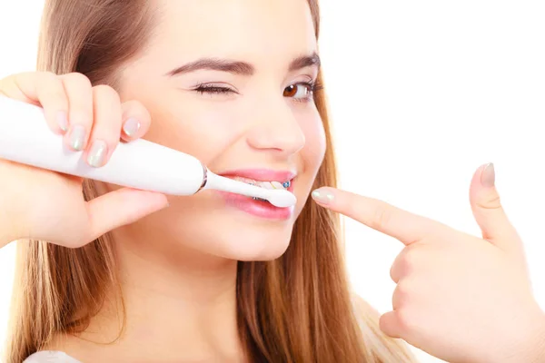 Mujer sonriendo limpiando dientes con aparatos ortopédicos — Foto de Stock