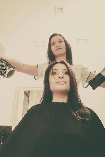 Salon fryzjerski suszenia ciemne włosy kobiece przy użyciu profesjonalnych suszarka do włosów — Zdjęcie stockowe