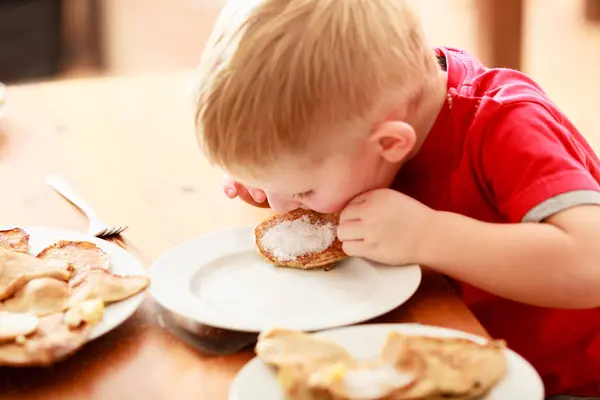 Kleine jongen eten van pannenkoeken voor breaktfast — Stockfoto