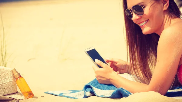 Kvinna på stranden sms på smartphone. — Stockfoto