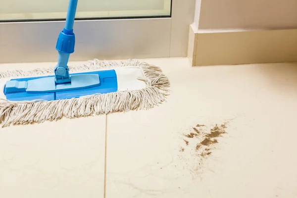 Dirty white floor with sand and cleaning mop — Stock Photo, Image