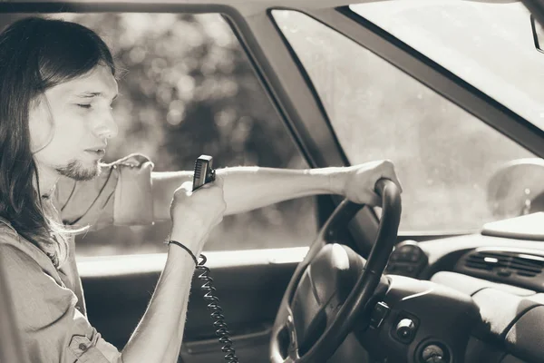 무 전기를 사용 하 여 자동차를 운전 하는 젊은 남자 — 스톡 사진