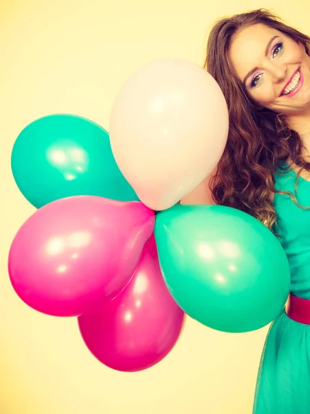 Kvinna som håller ett gäng färgglada ballonger — Stockfoto