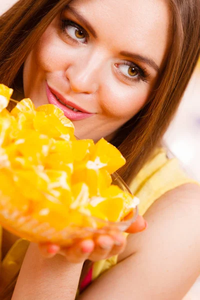 Mujer sostiene cuenco lleno de frutas de naranja en rodajas — Foto de Stock