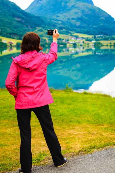 Turista tomando fotos en noruego lago de fiordos — Foto de Stock