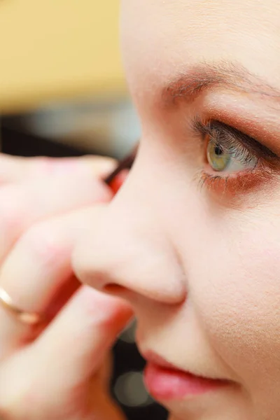 Fechar a mulher ficando maquiagem, sombra de olhos — Fotografia de Stock