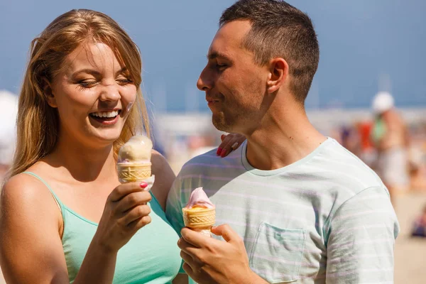 Mężczyzna i kobieta jedzący lody na plaży — Zdjęcie stockowe