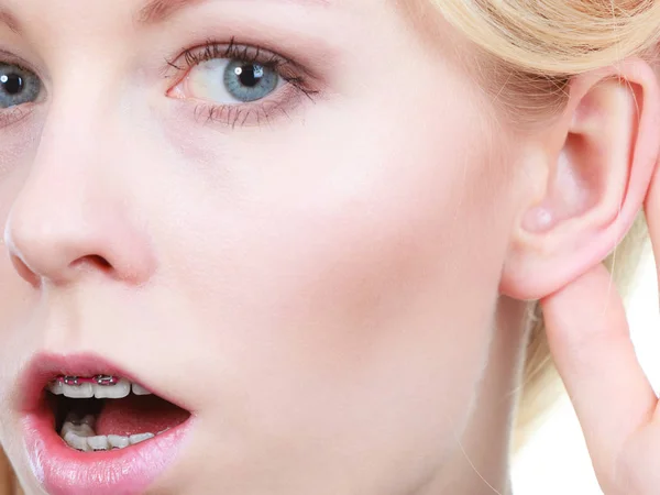 Vrouw luistert zorgvuldig met de hand dicht bij oor — Stockfoto