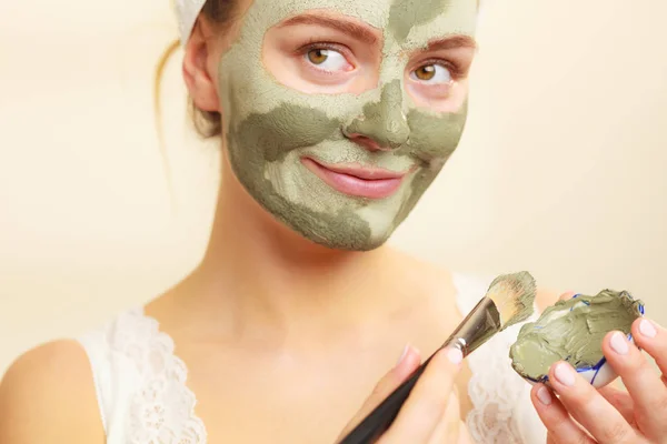 Woman applying with brush clay mud mask to her face — Stock Photo, Image