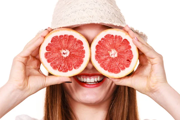 Meisje die betrekking hebben op ogen met twee helften van grapefruit citrusvruchten — Stockfoto