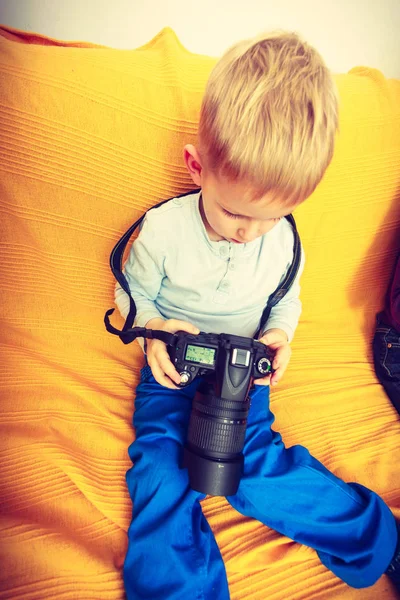 Kind spielt mit großer professioneller Digitalkamera — Stockfoto