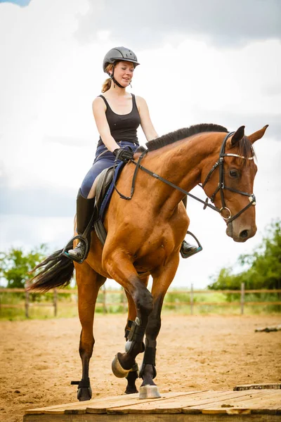 Jockey girl gör häst ridning på landsbygden äng — Stockfoto