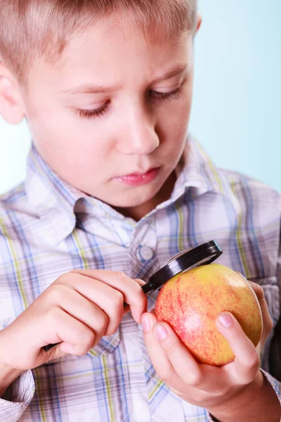 Kid examine apple with magnifying glass. — Stock Photo, Image