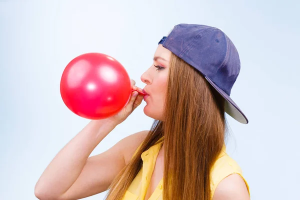 Femmina adolescente gonfiaggio palloncino rosso . — Foto Stock