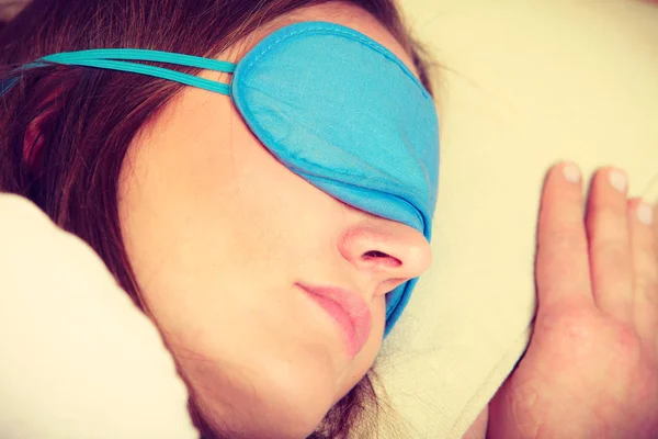 Bruneta žena spí v modré oko spánku masku — Stock fotografie