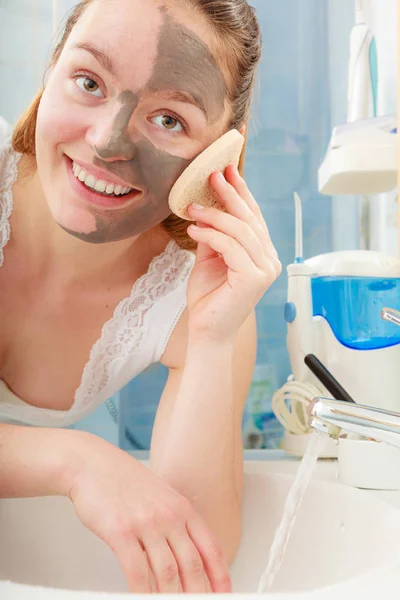 Žena, odstranění obličejových jíl Bahenní maska v koupelně — Stock fotografie