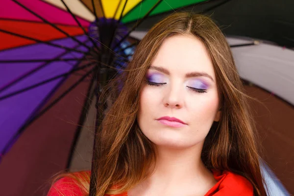 Kvinna som står under mångfärgad paraply — Stockfoto
