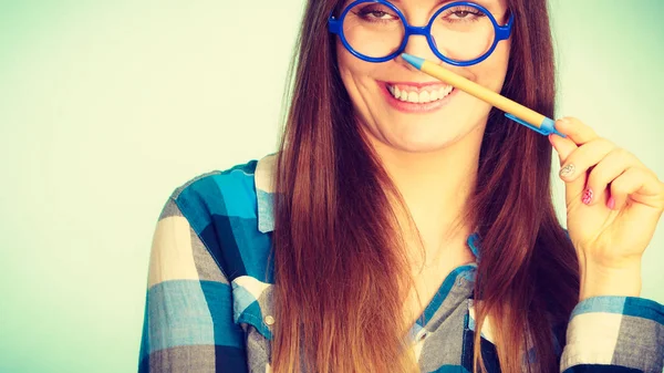 Feliz mujer nerd en gafas celebración pluma — Foto de Stock