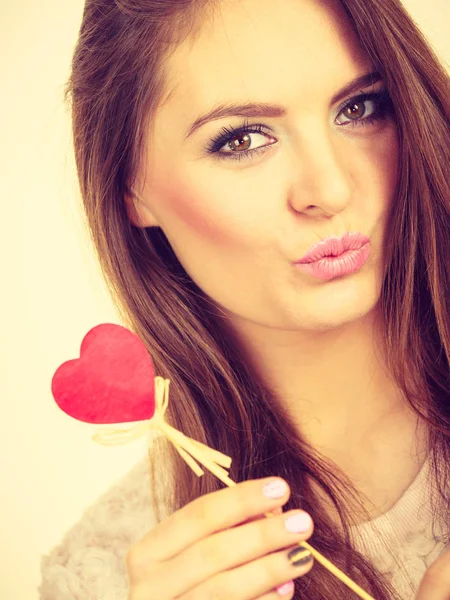 Mujer coqueta sosteniendo el corazón de madera roja en palo —  Fotos de Stock